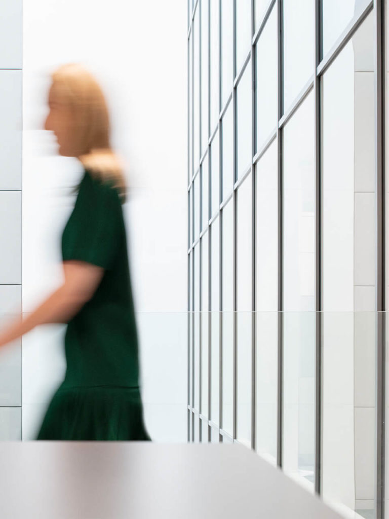 This photograph shows a person in in an office environment. The person is blurred to suggest motion. The person could be a member of the Fintech team.