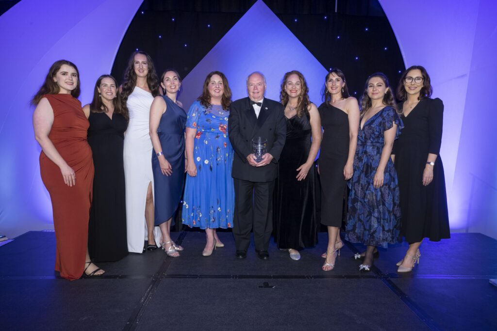 Picture of named people below at the 2023 Chambers Ireland Sustainable Business Impact Awards. Male in the middle hols the award.

