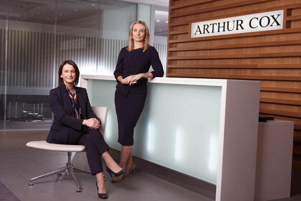 Caitriona Gibson (seated) and Lynsey Mallon in the entrance lobby of Arthur Cox Northern Ireland office