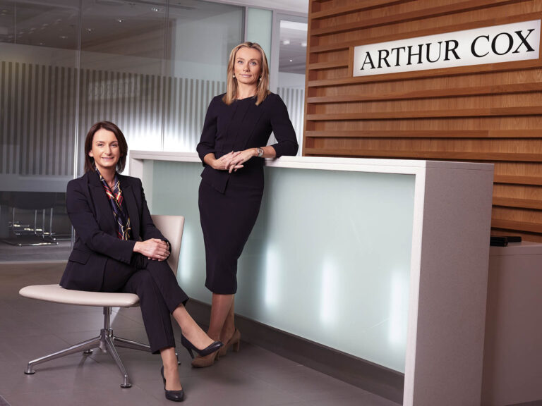 Caitriona Gibson (seated) and Lynsey Mallon in the entrance lobby of Arthur Cox Northern Ireland office