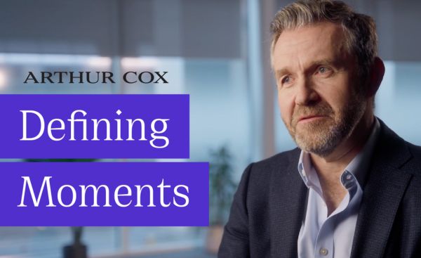 Text on screen Defining Moments. Geoff Moore looks to an interviewer offscreen